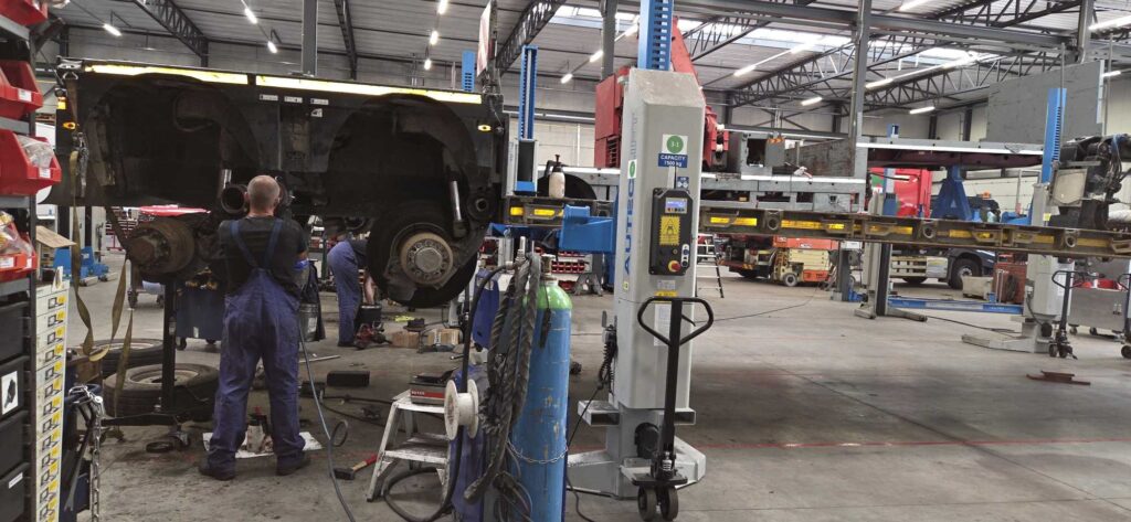 LMJ-technieker werkt aan gestuurde assen van MAX Trailer dieplader